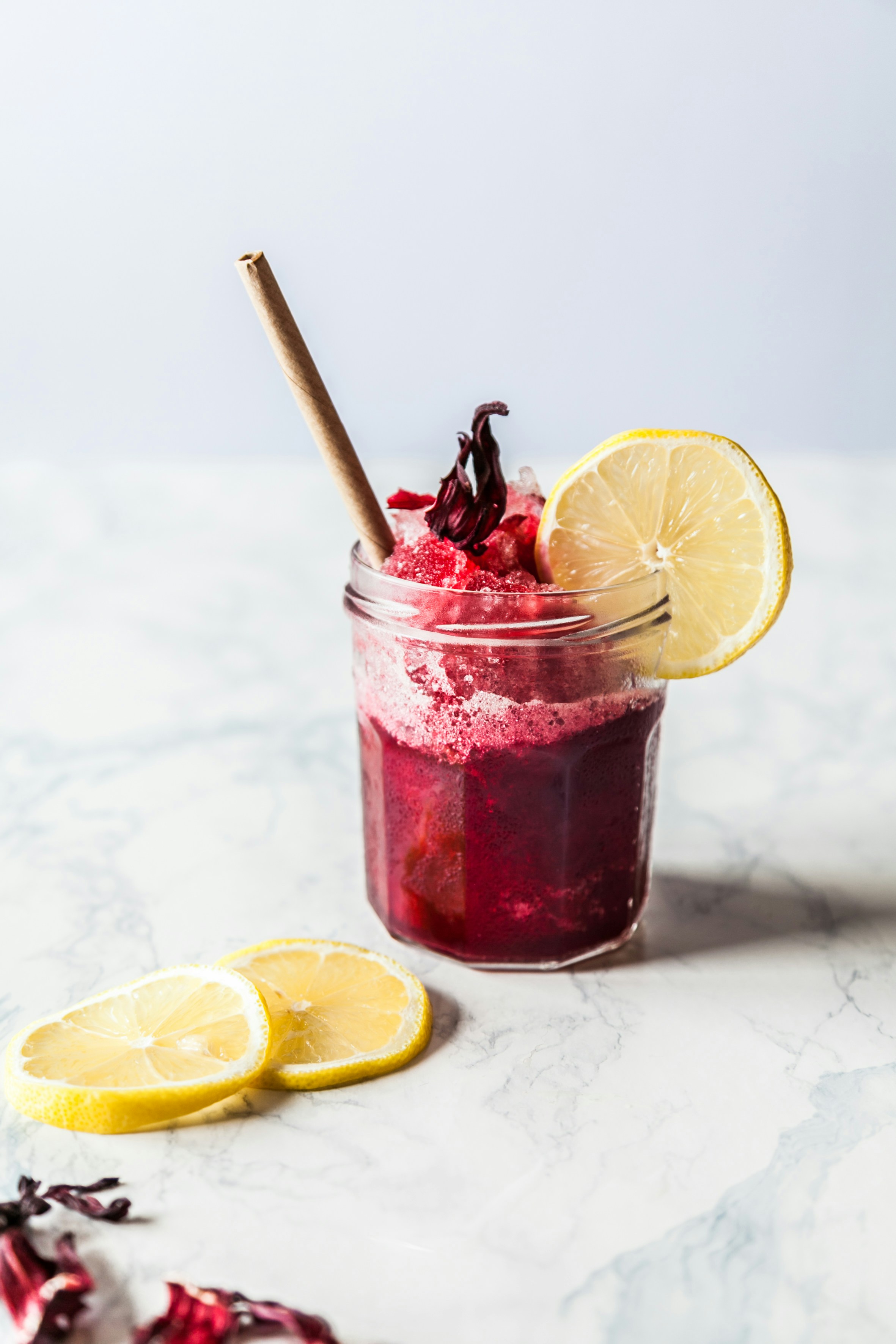 An example base image. A glass jar contains a red liquid with a
           lemon slice on the side and a straw sticking out. Lemon slices are
           visible in the left foreground