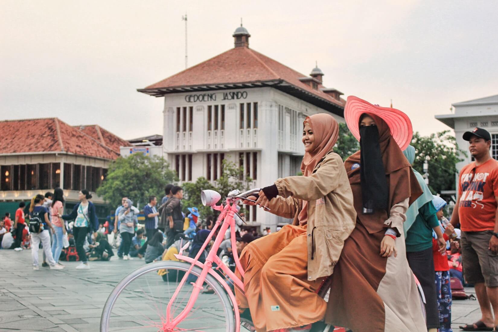 Two women biking in Jakarta.